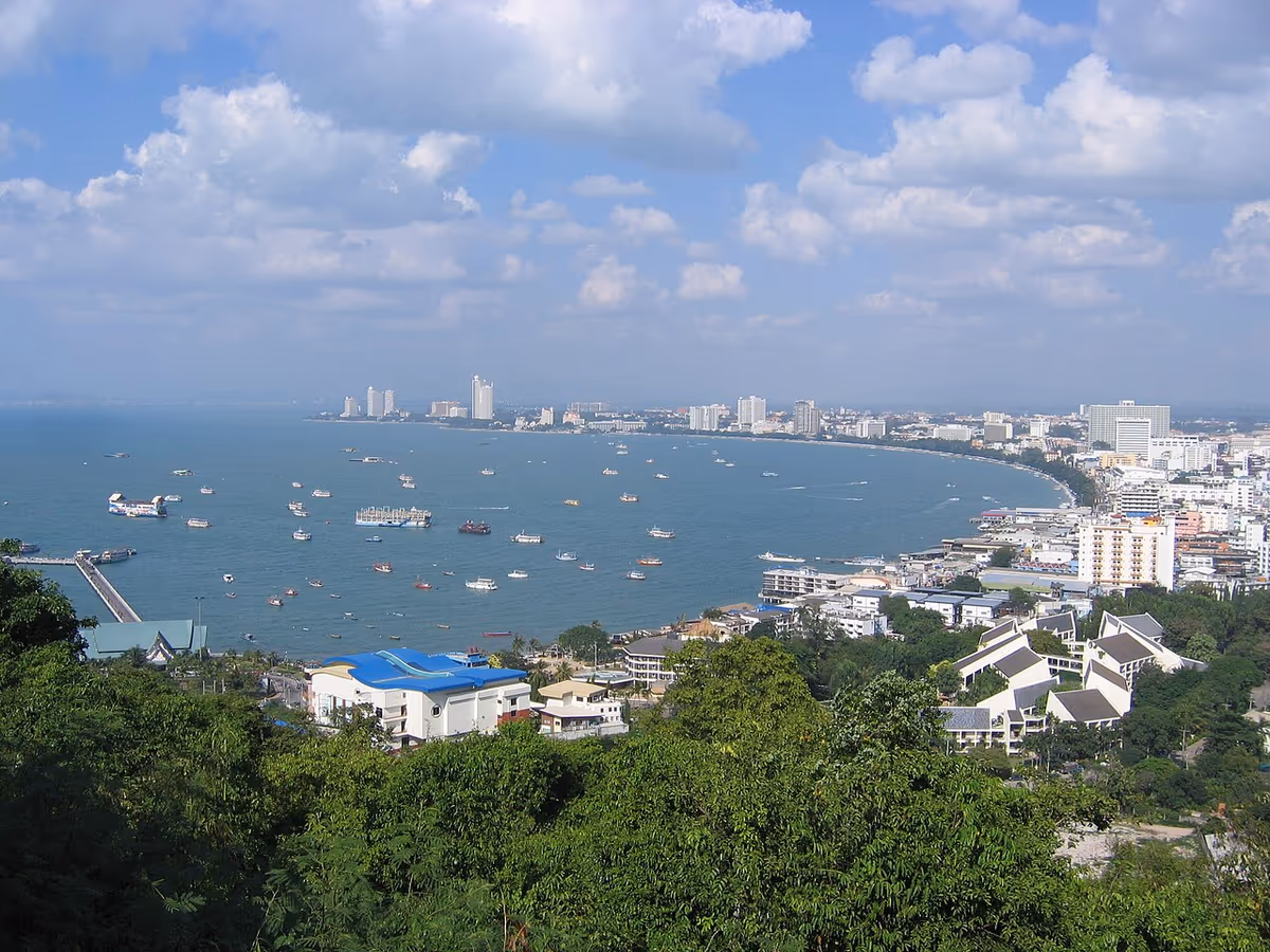 Vue en hauteur de la baie de Pattaya avec bateaux, gratte-ciels et collines verdoyantes