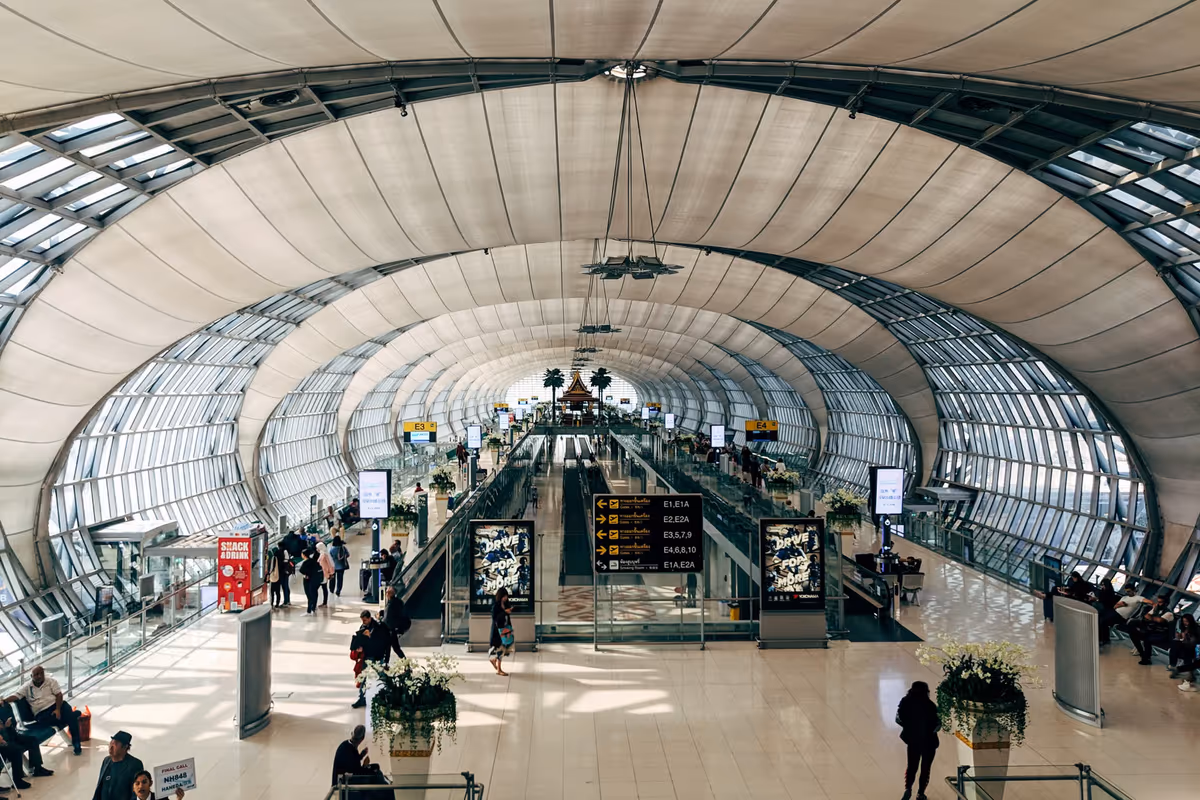Intérieur de l'aéroport Suvarnabhumi en Thaïlande avec toit incurvé et escalators