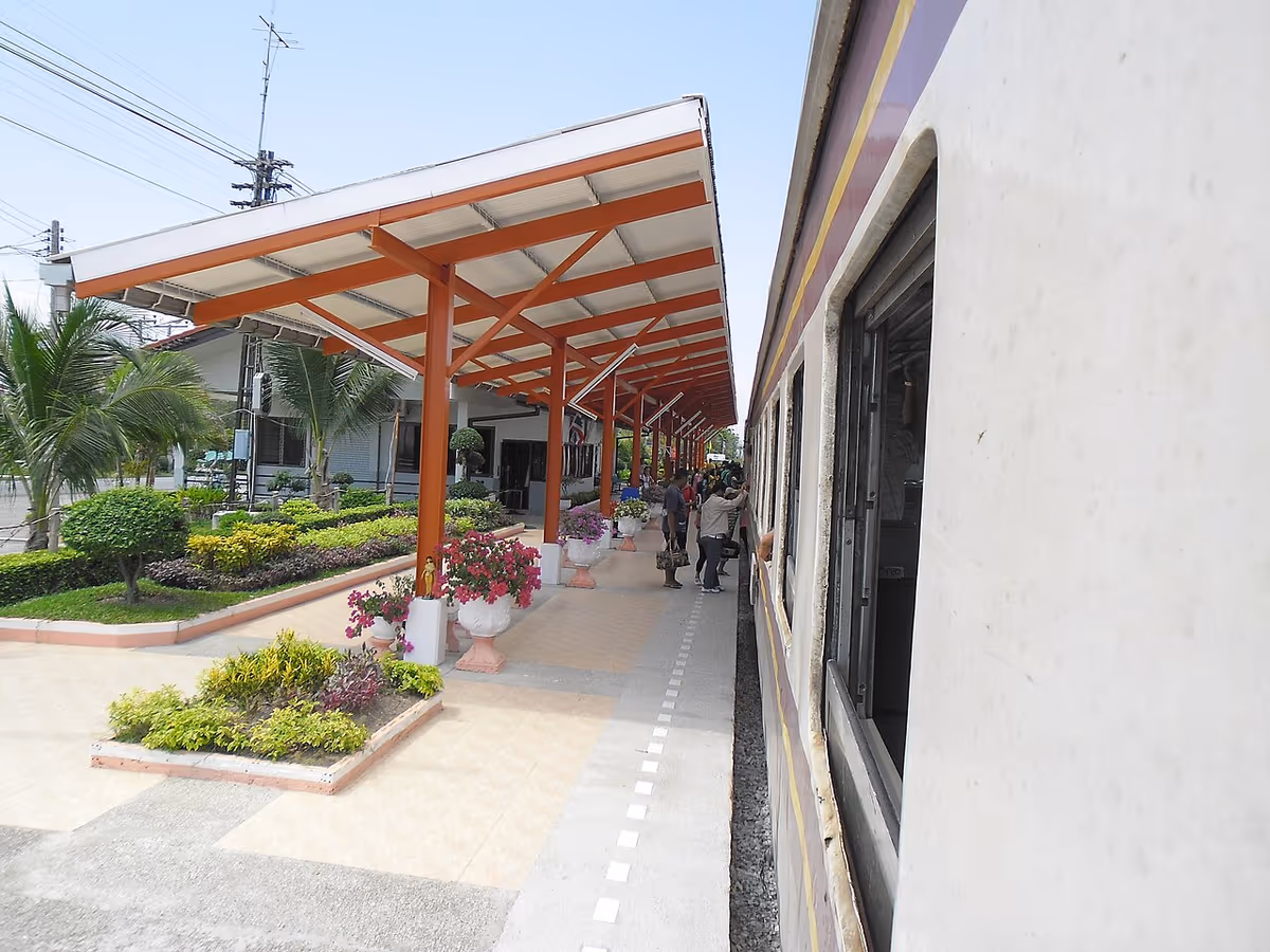Covered platform with orange pillars beside a train at Pattaya railway station