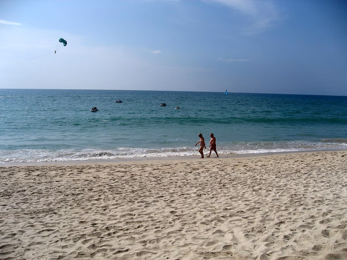 Bang Tao Beach on Phuket with two people walking along the sand